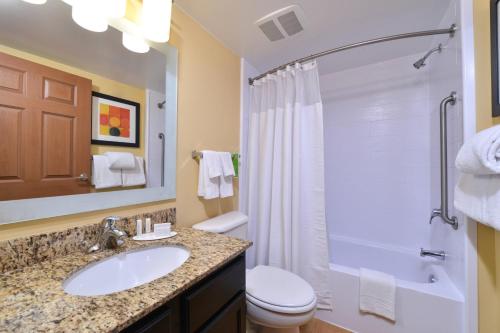 y baño con lavabo, aseo y ducha. en TownePlace Suites Miami West Doral Area en Miami