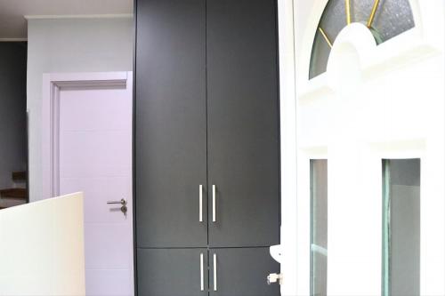 a kitchen with a black cabinet next to a door at Red Kruz in Vračar (historical)