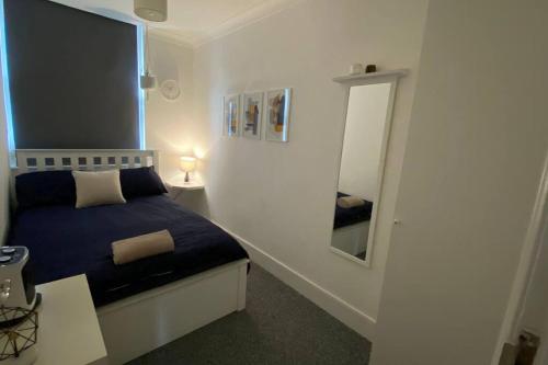 una piccola camera con letto e specchio di 2 Bedroom Flat in Camberwell Green - Central Location with excellent connections to tourist attractions and main London airports a Londra