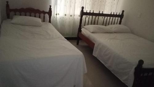 twee bedden naast elkaar in een slaapkamer bij casa 4 cocorna in Cocorná
