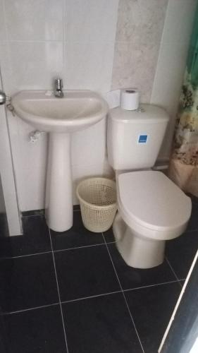 a bathroom with a white toilet and a sink at casa 4 cocorna in Cocorná