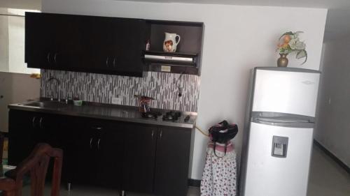 een keuken met een witte koelkast en een magnetron bij casa 4 cocorna in Cocorná