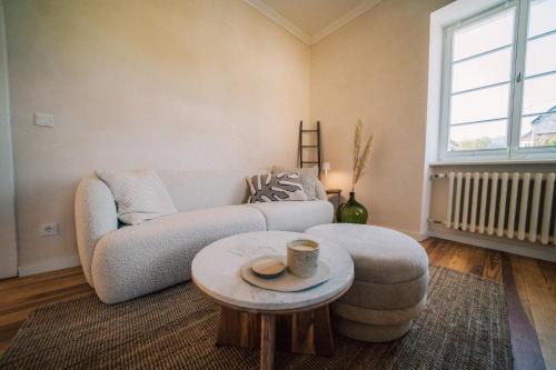 a living room with a couch and a coffee table at Gut Försterlay - Exklusive Boutique Apartments im historischen Winzerhaus direkt an der Mosel in Lösnich