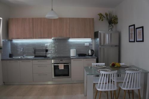 een keuken met een aanrecht en een tafel met stoelen bij Atalia Apartment, Orne Crete in Orné