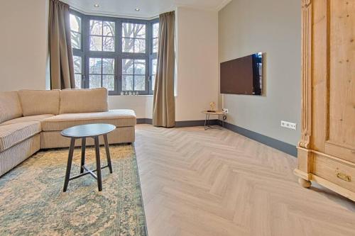 a living room with a couch and a table and a tv at PRIVATE APPARTMENT 60m2 - CENTRE TOP LOCATION in Amsterdam