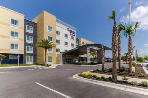 a view of a hotel with palm trees and a parking lot at Fairfield Inn & Suites by Marriott Panama City Beach in Panama City Beach