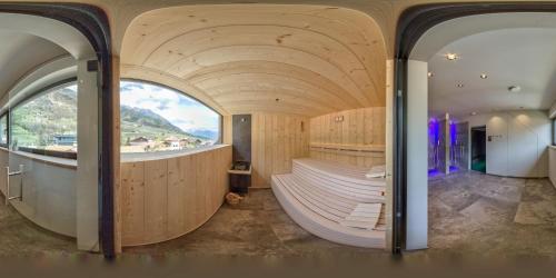 une chambre avec une grande fenêtre et une chambre ronde avec des bancs dans l'établissement Guesthouse Karnatsch, à Parcines