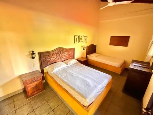 Hotel Rancho Escondito في بويرتو إسكونديدو: غرفة نوم بسرير كبير وطاولة