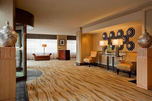 une chambre d'hôtel avec un hall doté de chaises et de tables dans l'établissement The Westin Poinsett, Greenville, à Greenville