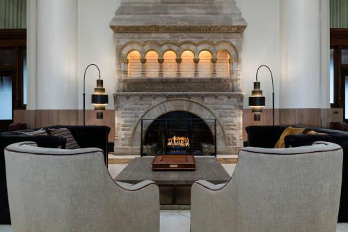 a living room with a fireplace and a table and chairs at The Union Station Nashville Yards, Autograph Collection in Nashville