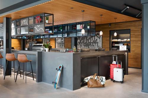 a bar in a restaurant with a counter and stools at Moxy Bristol in Bristol