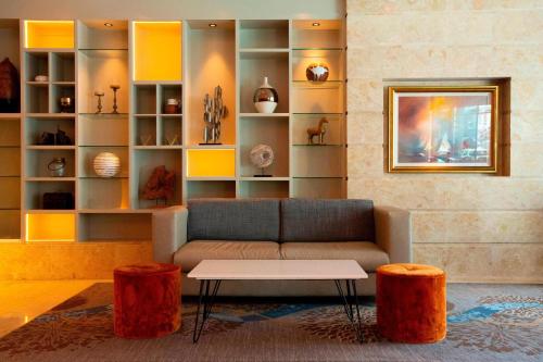 a living room with a couch and two orange stools at Sheraton Athlone Hotel in Athlone