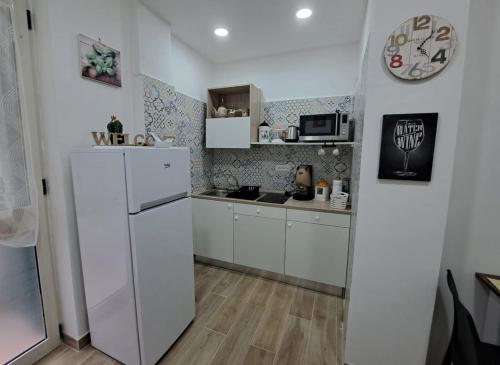 a small kitchen with a refrigerator and a sink at Domus de loco sano in Castellammare di Stabia