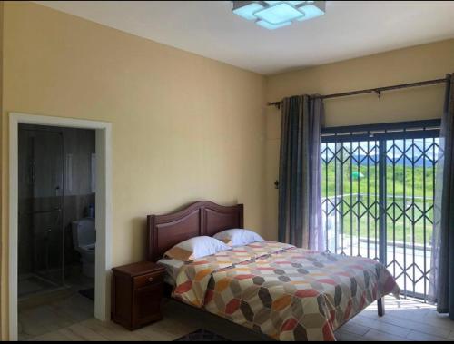 een slaapkamer met een bed en een glazen schuifdeur bij Grand View Villa in Pont Colville