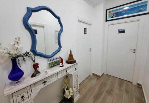 a dressing room with a mirror and a door at Domus de loco sano in Castellammare di Stabia