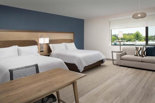 a hotel room with two beds and a table and a couch at Element Seattle Sea-Tac Airport in Tukwila