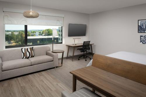 a hotel room with a bed and a couch and a desk at Element Seattle Sea-Tac Airport in Tukwila