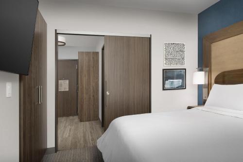 a bedroom with a large white bed and a sliding door at Element Seattle Sea-Tac Airport in Tukwila