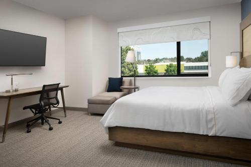 a hotel room with a bed and a desk and a window at Element Seattle Sea-Tac Airport in Tukwila