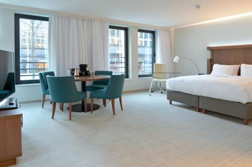 布魯塞爾的住宿－布魯塞爾歐盟萬怡酒店，酒店客房带一张床、一张桌子和椅子