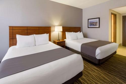 a hotel room with two beds and a lamp at Best Western Lock Haven in Lock Haven
