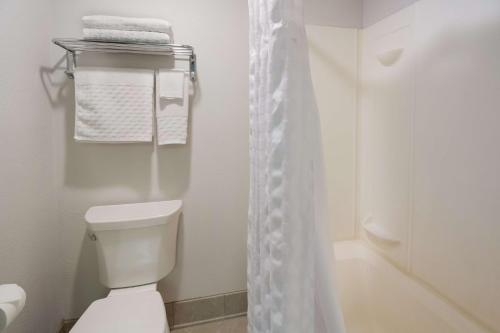 uma casa de banho branca com um WC e um chuveiro em Best Western Lock Haven em Lock Haven