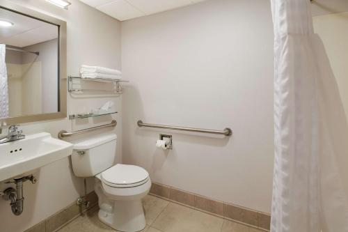 a bathroom with a toilet and a sink and a mirror at Best Western Lock Haven in Lock Haven