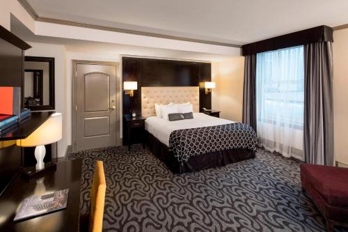 ダベンポートにあるHotel Blackhawk, Autograph Collectionのベッドとデスクが備わるホテルルームです。