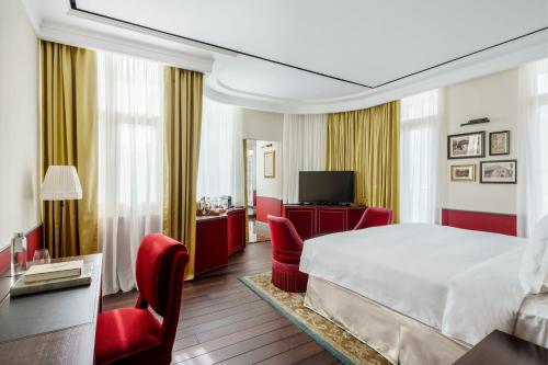ein Hotelzimmer mit einem Bett und roten Stühlen in der Unterkunft Maxwell Reserve Singapore, Autograph Collection in Singapur