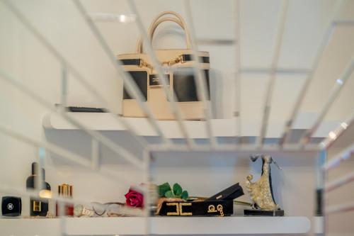 a shelf with a group of purses and shoes at Uniquely designed Villa Ivana with outdoor Jacuzzi nearby the pebble Banje beach at the Island of Solta in Rogač