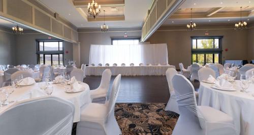 une salle de banquet avec des tables blanches et des chaises blanches dans l'établissement Prestige Harbourfront Resort, WorldHotels Luxury, à Salmon Arm