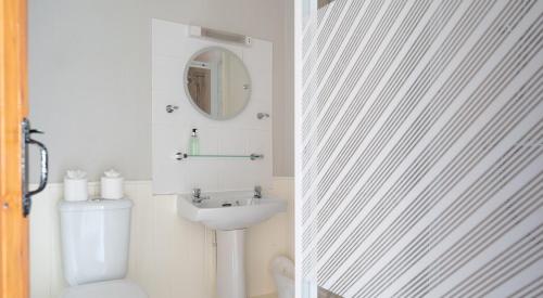a bathroom with a toilet and a sink and a mirror at Ullswater at the Graythwaite Estate in Ambleside