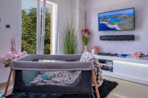 a chair in a room with a tv on a wall at Uniquely designed Villa Ivana with outdoor Jacuzzi nearby the pebble Banje beach at the Island of Solta in Rogač