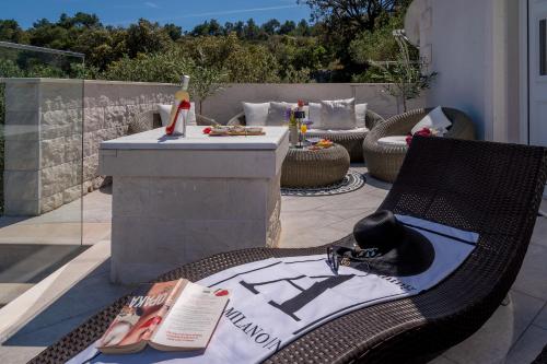 a patio with chairs and a table with shoes on it at Uniquely designed Villa Ivana with outdoor Jacuzzi nearby the pebble Banje beach at the Island of Solta in Rogač