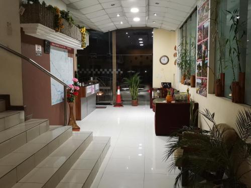 een hal met trappen en planten in een gebouw bij HOTEL 4 RIOS in Cuenca