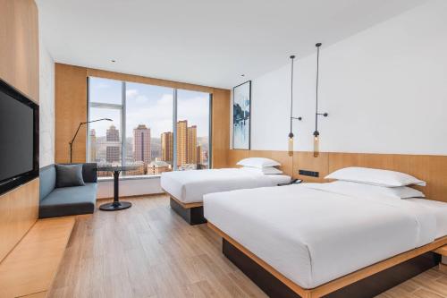 西寧市にあるFairfield by Marriott Xining Northのベッド2台、薄型テレビが備わるホテルルームです。