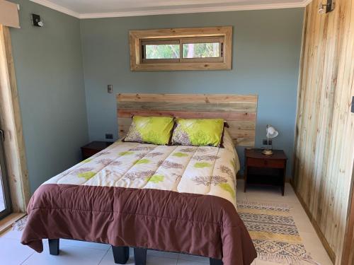 a bedroom with a bed with a wooden headboard and a window at Viejoboldo_latrinchera in Los Rábanos