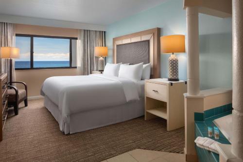a bedroom with a large white bed and a large window at Vistana Beach Club in Jensen Beach