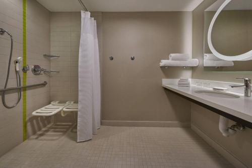 La salle de bains est pourvue d'une douche, de toilettes et d'un lavabo. dans l'établissement SpringHill Suites by Marriott Toronto Vaughan, à Vaughan