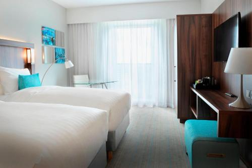 a hotel room with two beds and a window at Courtyard by Marriott Amsterdam Arena Atlas in Amsterdam