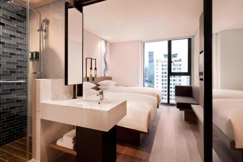 baño con 2 camas, lavabo y espejo en Fairfield by Marriott Seoul en Seúl