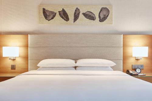 a bedroom with a large white bed with two lamps at Courtyard by Marriott Seoul Pangyo in Seongnam