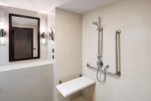 La salle de bains blanche est pourvue d'un lavabo et d'un miroir. dans l'établissement Sheraton Samoa Beach Resort, à Mulifanua