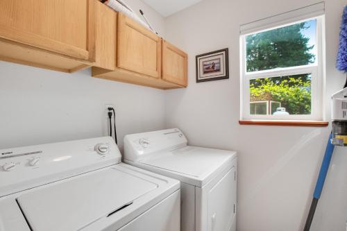 een wasruimte met een wasmachine en droger en een raam bij Northwest Stunner in Union