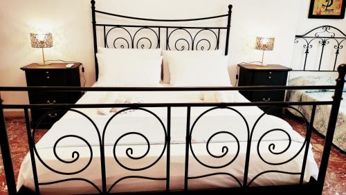 a bedroom with a black bed with two night stands at LA BARONESSA apartment- vicinissimo al policlinico in Messina