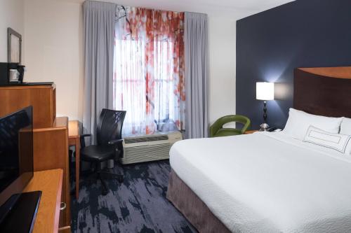a hotel room with a bed and a desk and a window at Fairfield Inn Suites by Marriott Orlando At SeaWorld in Orlando