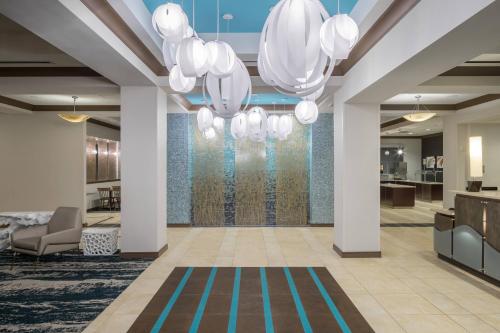 um átrio com lustres brancos num edifício em Fairfield Inn Suites by Marriott Orlando At SeaWorld em Orlando