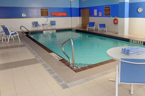 uma grande piscina com cadeiras e uma mesa em Four Points by Sheraton Cambridge Kitchener, Ontario em Cambridge