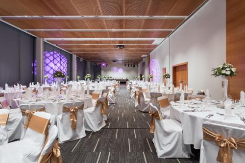 a banquet hall with white tables and chairs at Four Points by Sheraton Ljubljana Mons in Ljubljana