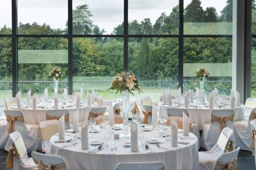 a room with white tables and chairs and windows at Four Points by Sheraton Ljubljana Mons in Ljubljana